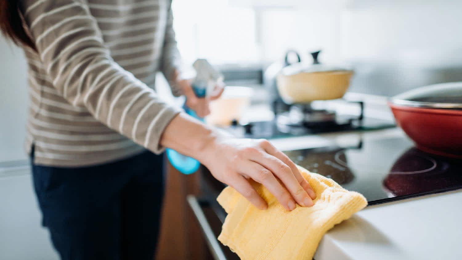 A person cleaning a stove