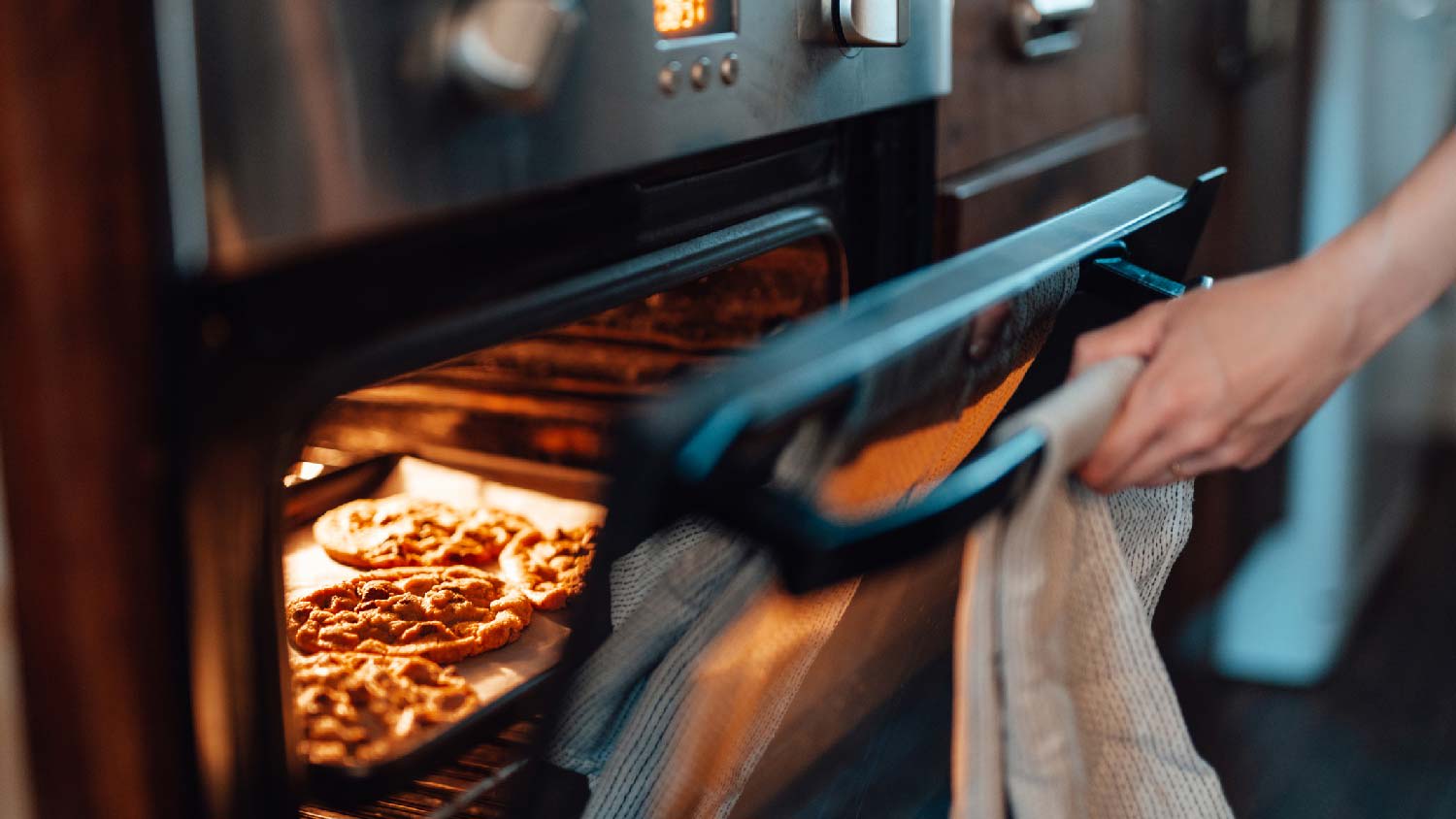 A person opening a stove door