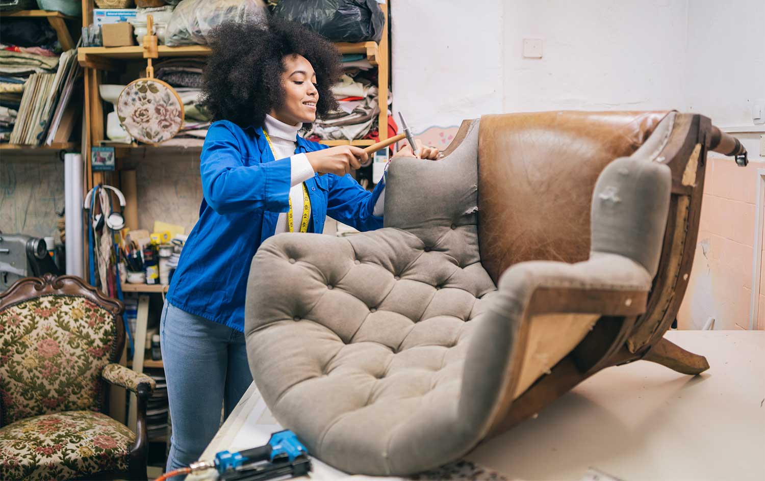 Woman refurbishing armchair in workshop