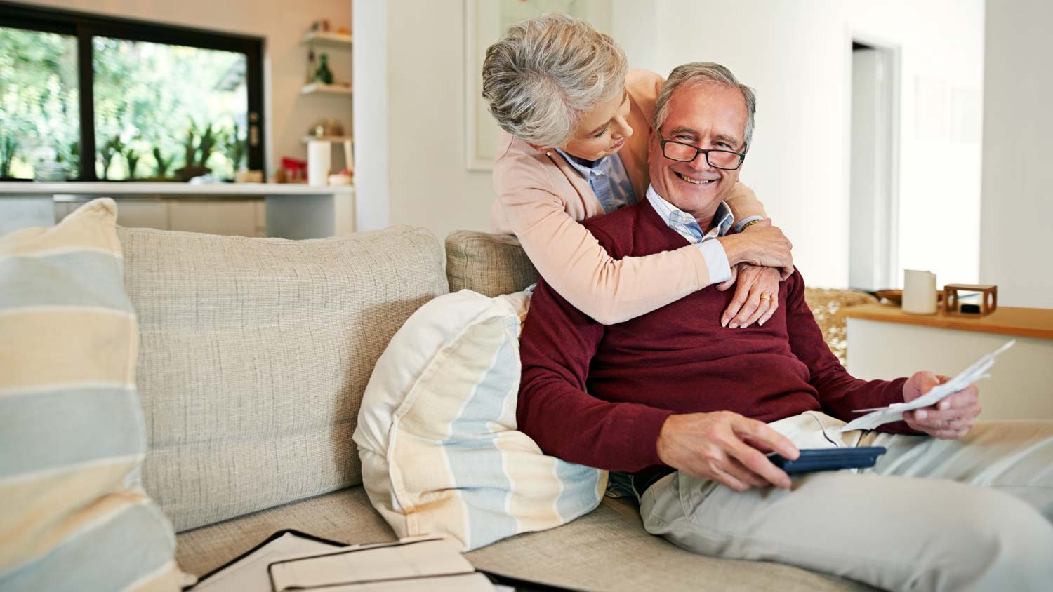 elderly couple at home hugging