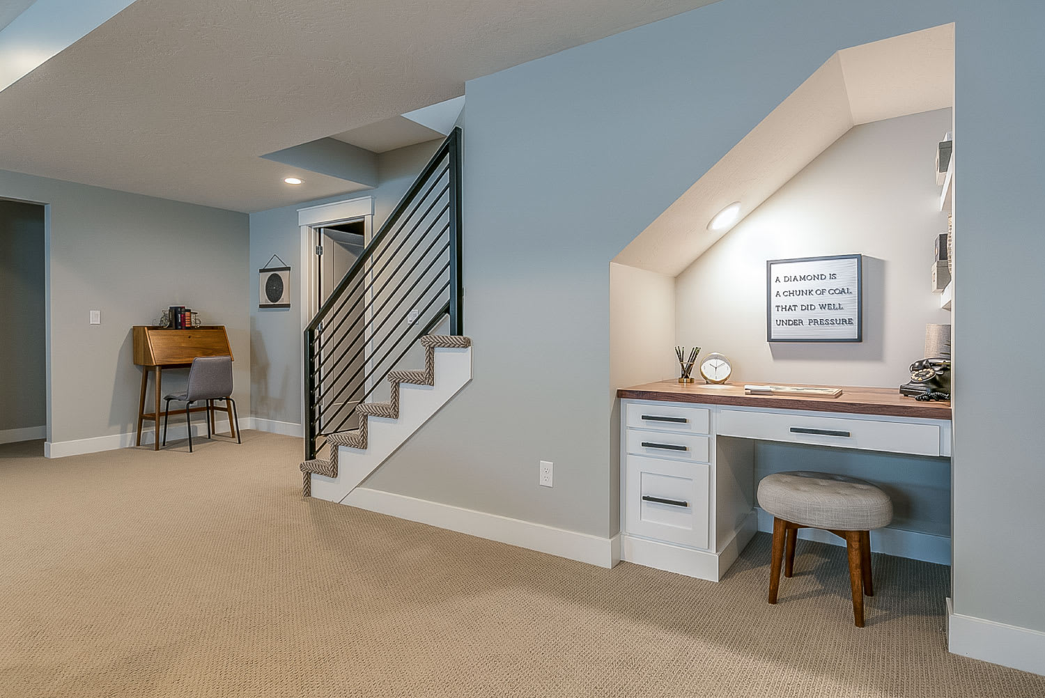 Basement room with home office desk underneath the stairs