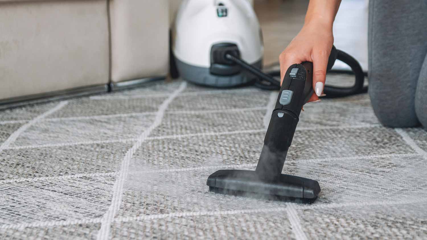 Woman cleaning carpet with a steam cleaner