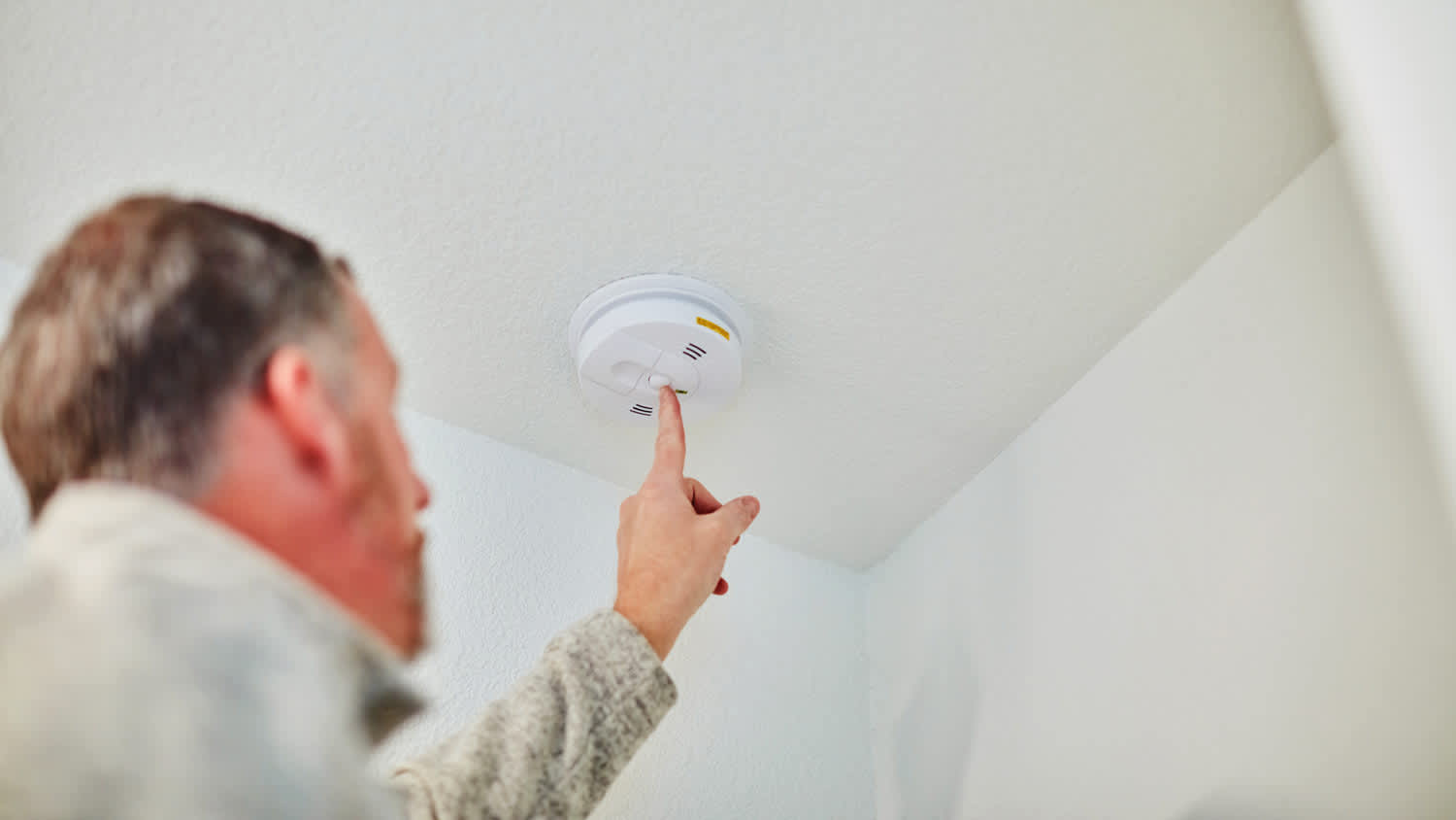 man checking carbon monoxide detector