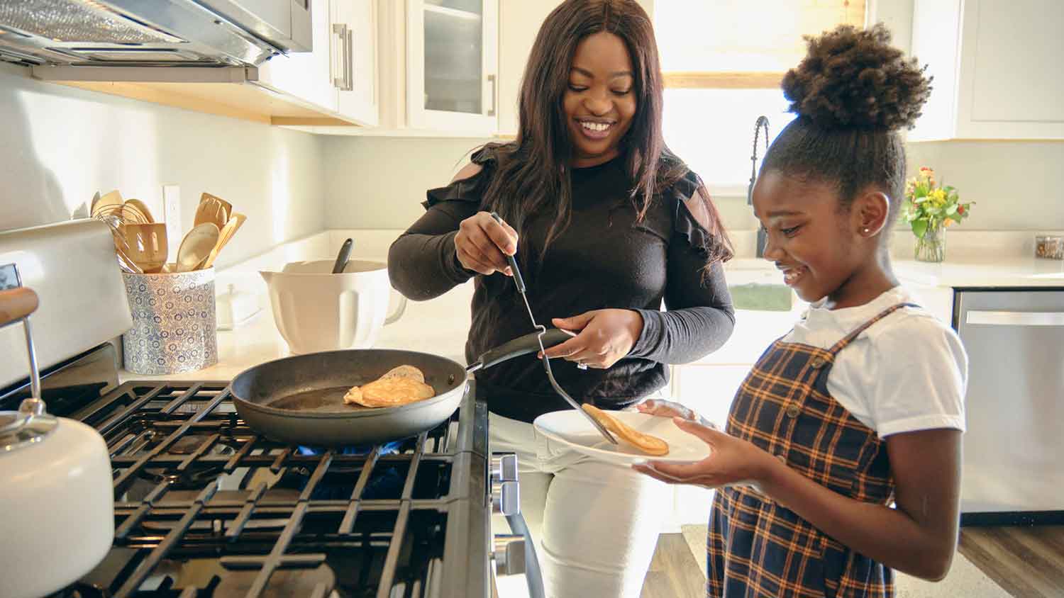 Woman cooking breakfast for her daughter