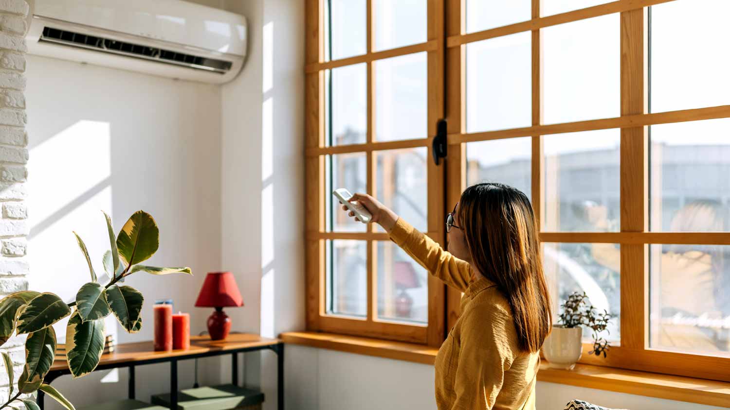 Woman using the remote to change the room temperature