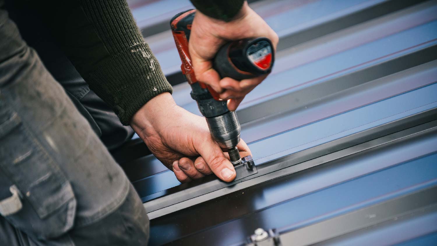 Close-up of a person repairing a metal roof
