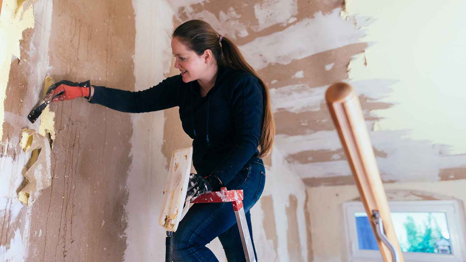 Wallpaper removal specialist removing old wallpaper from the walls