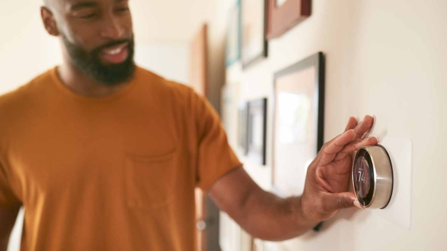 Man adjusting heating thermostat