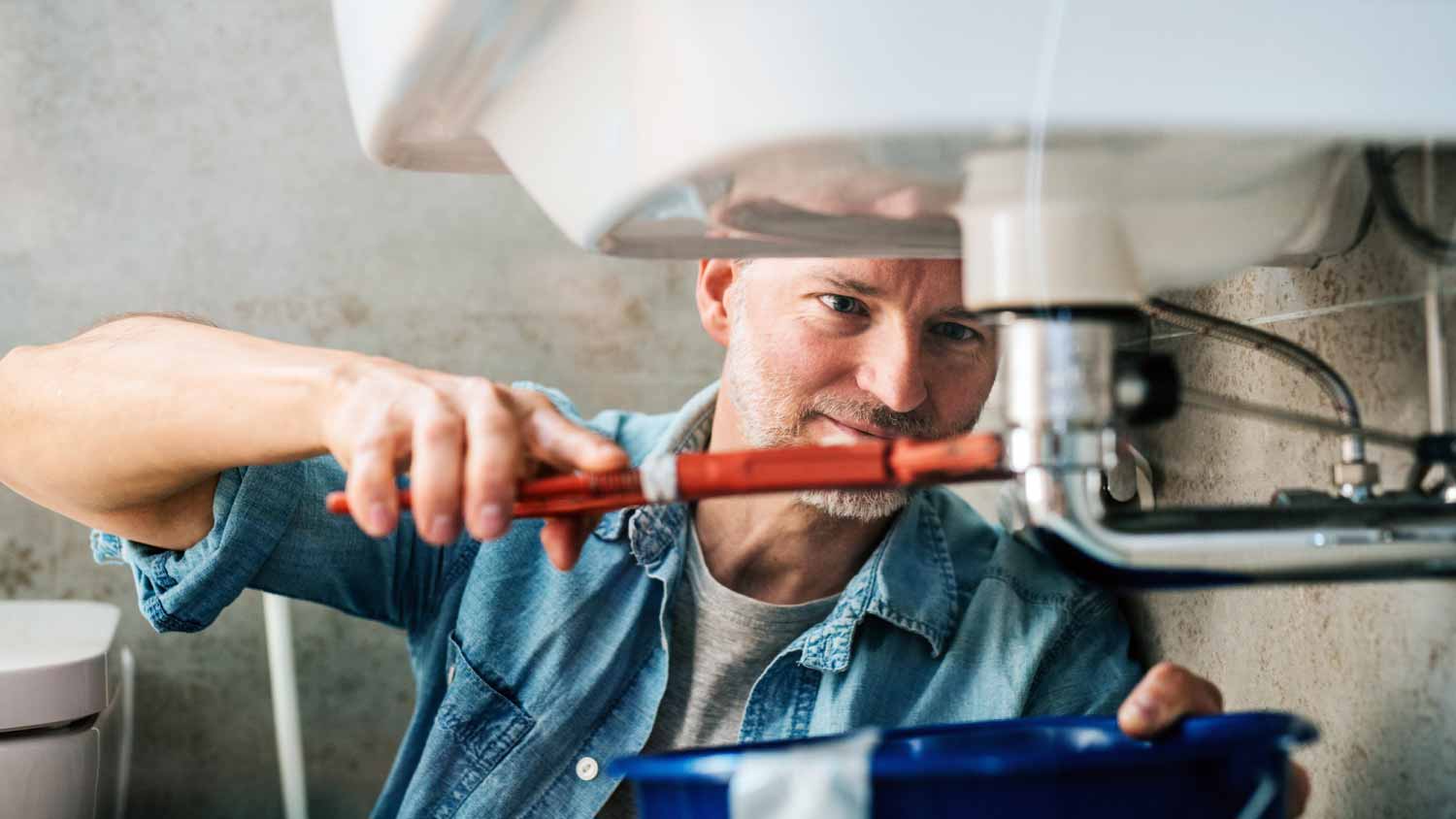 Man fixing a leak in a sink