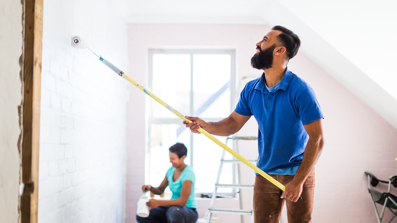 A couple painting together a room of their home