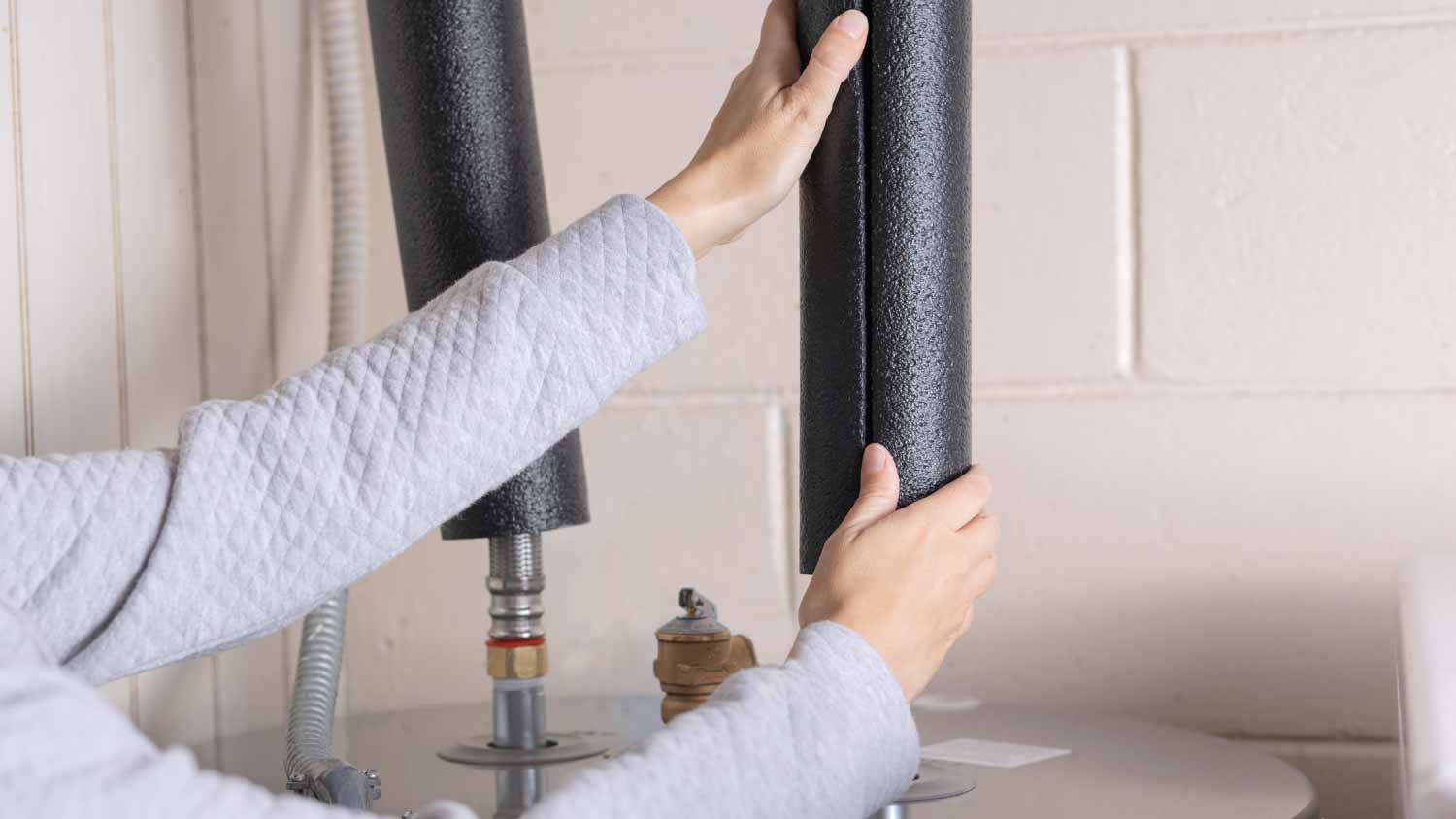 Man installing pipe insulation