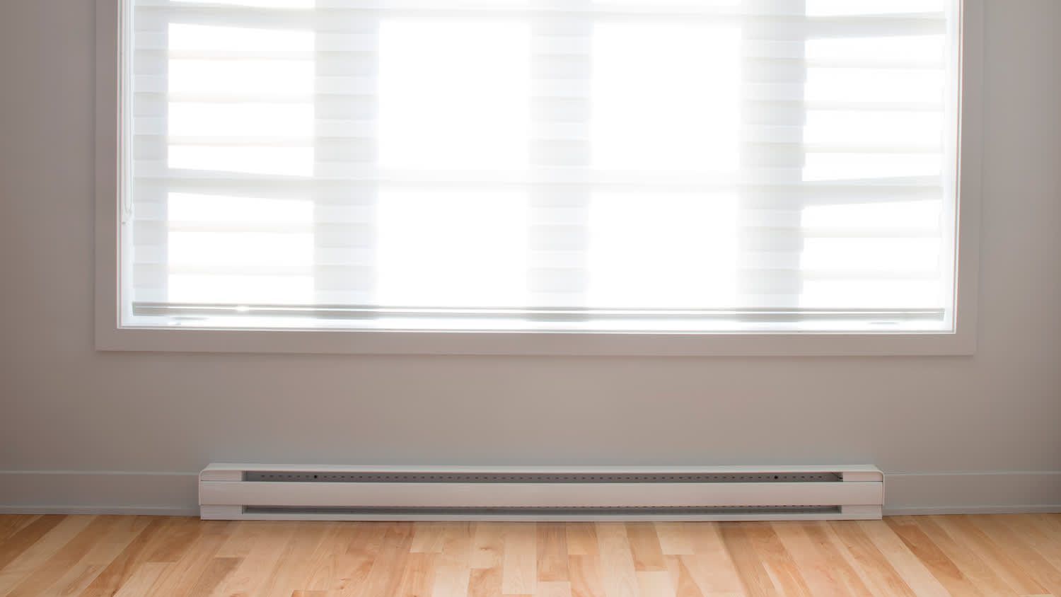 Room with large sunny window and baseboard heating
