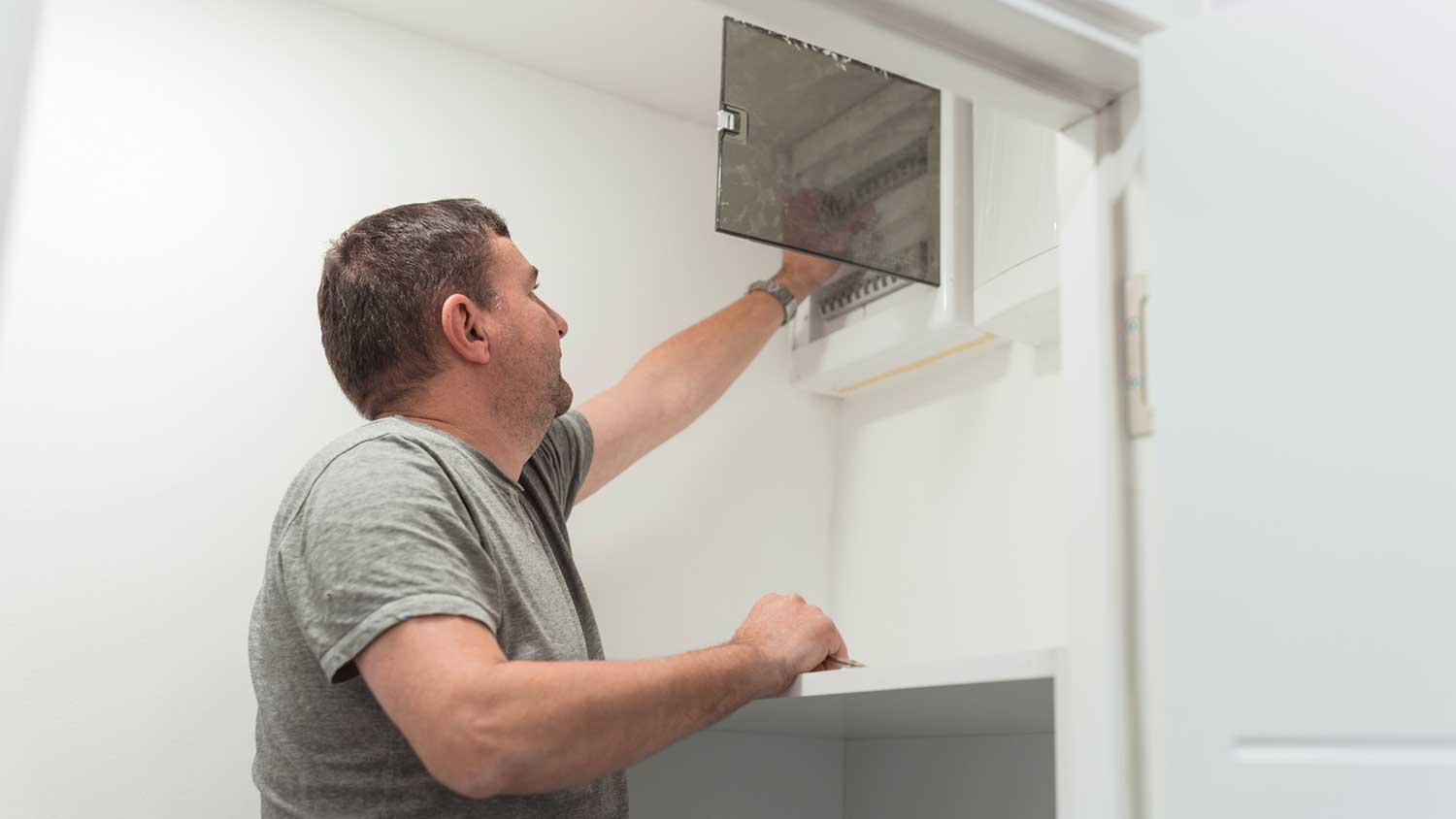 Electrician checking breaker box installed in the basement