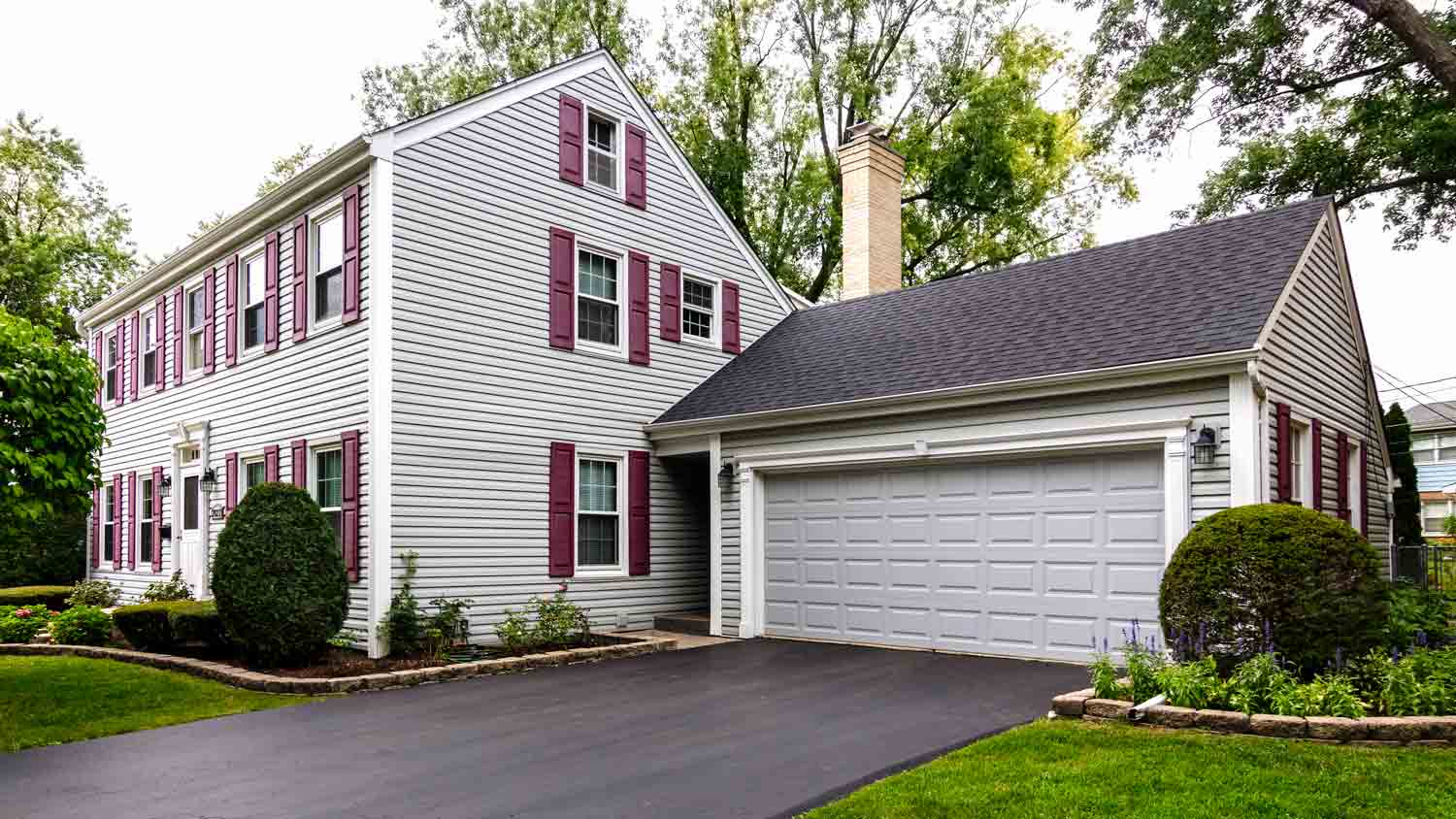 white colonial house with asphalt driveway