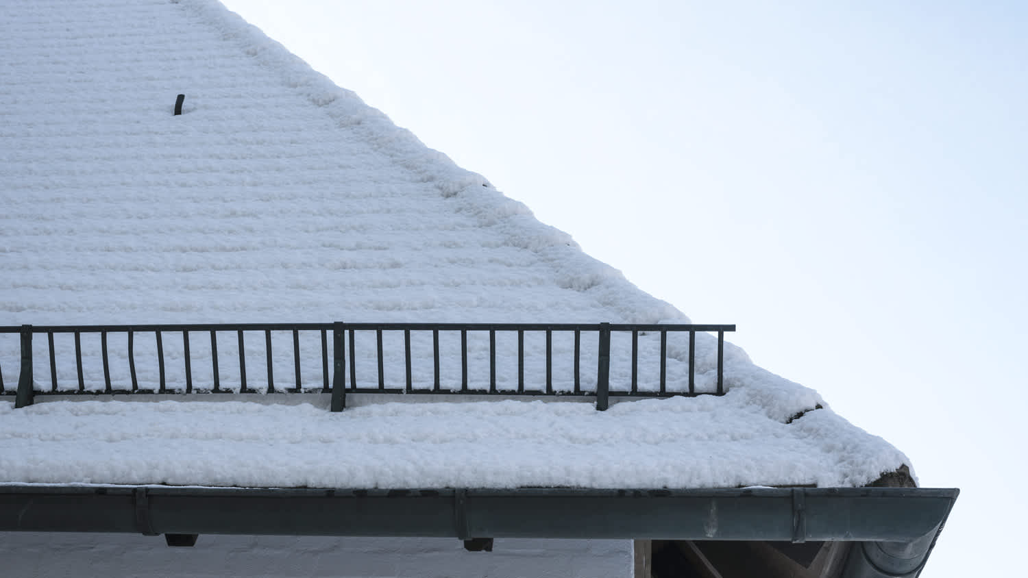 Snow covered roof with snow fence.