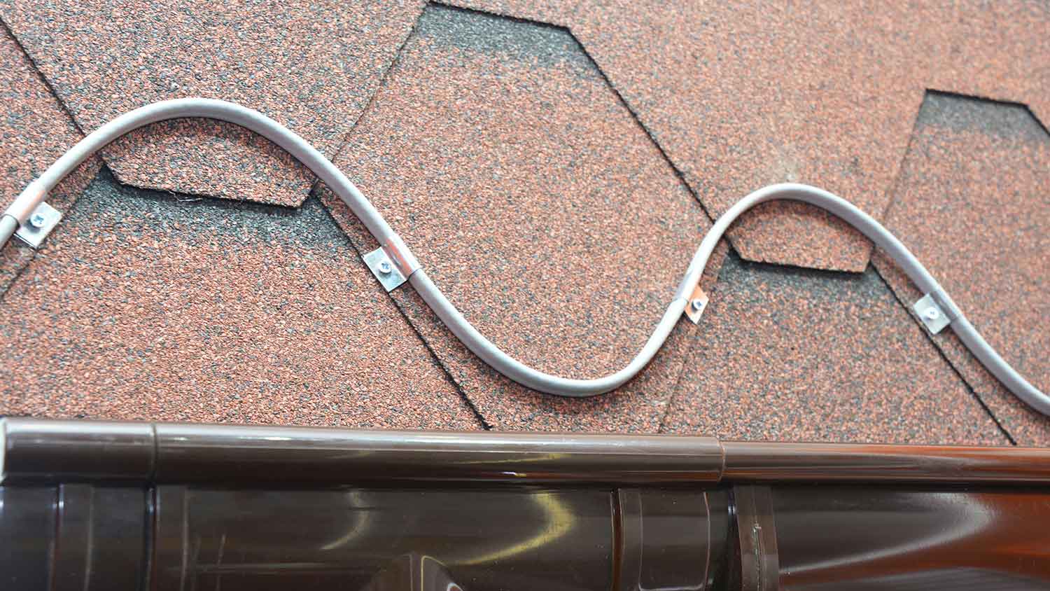 Roof heating cable installed above the rain gutter