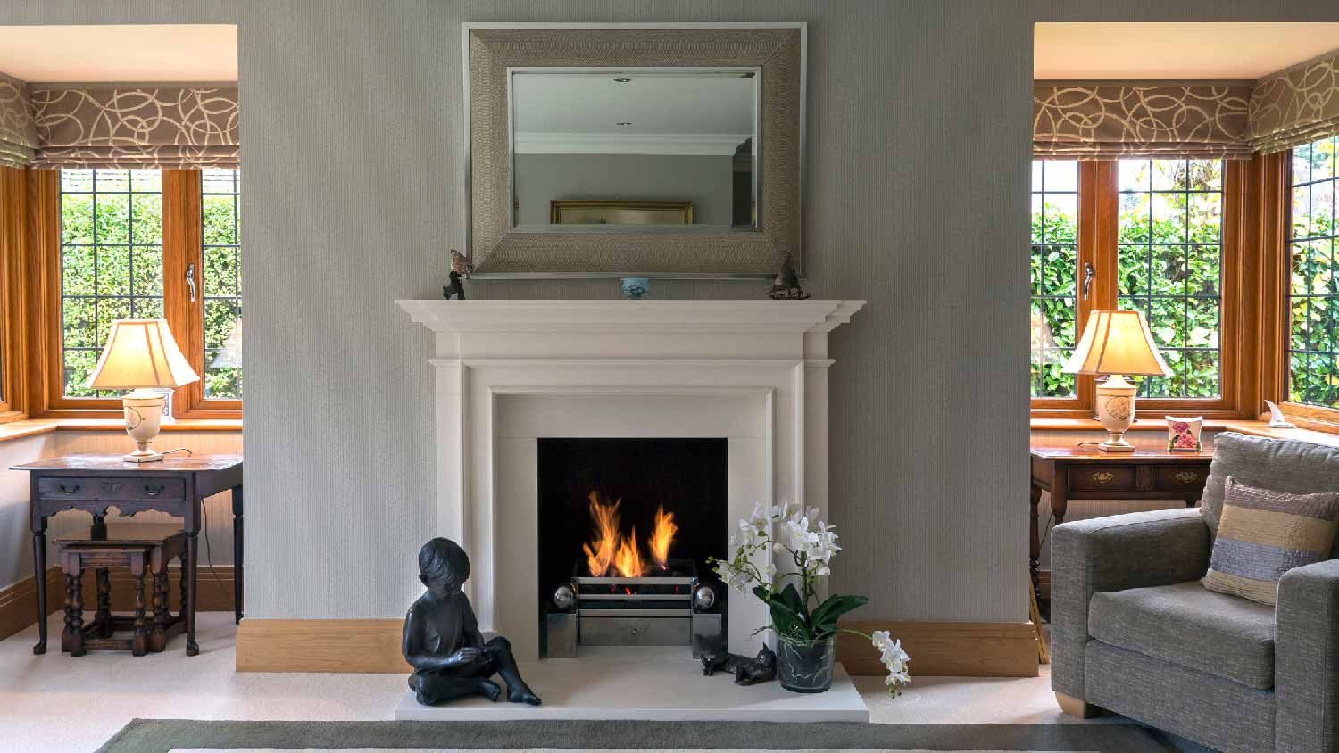 A living room with an armchair and a burning fireplace