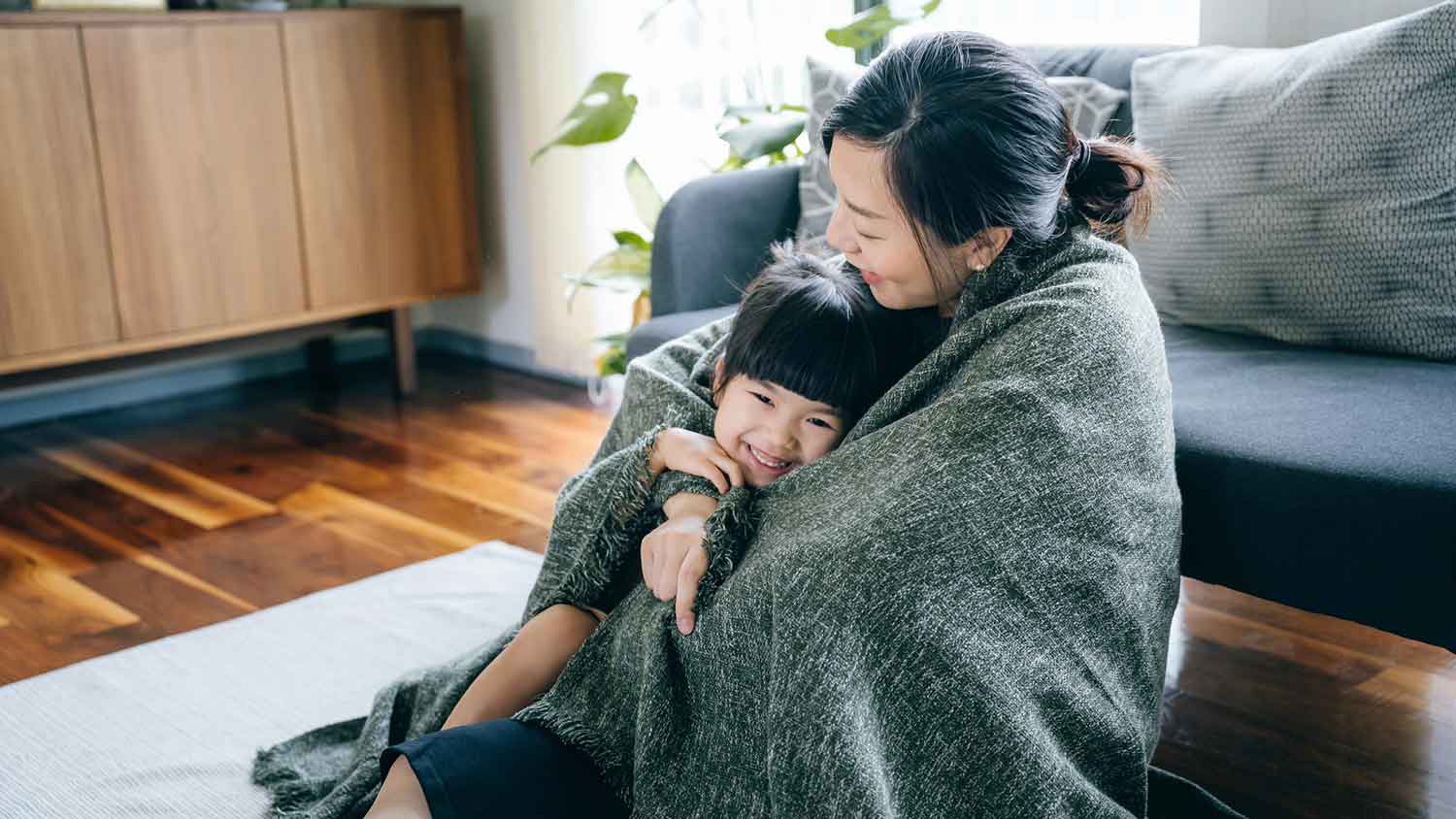 Mother and daughter wrapped in a blanket