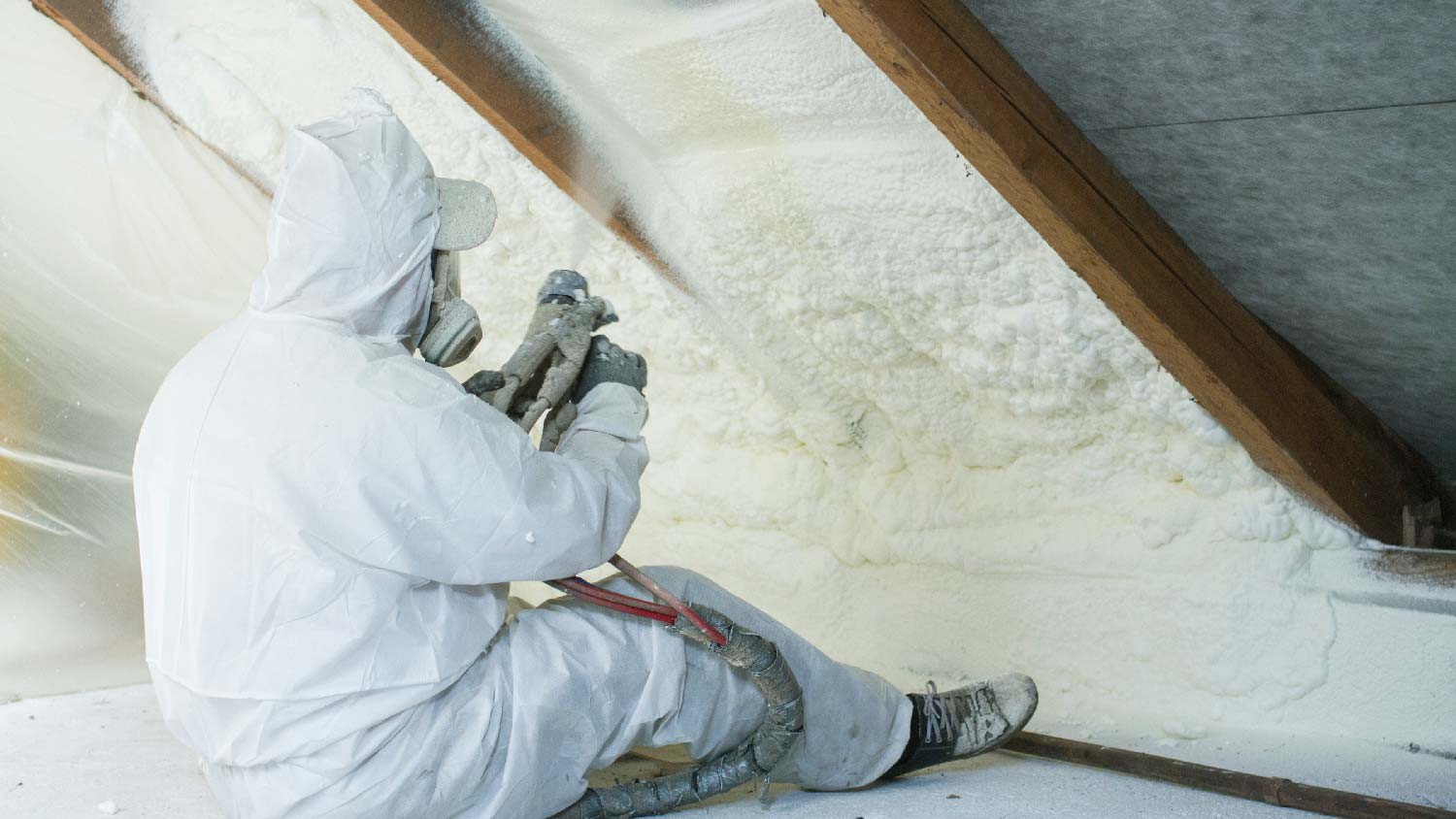 A person applying spray foam insulation