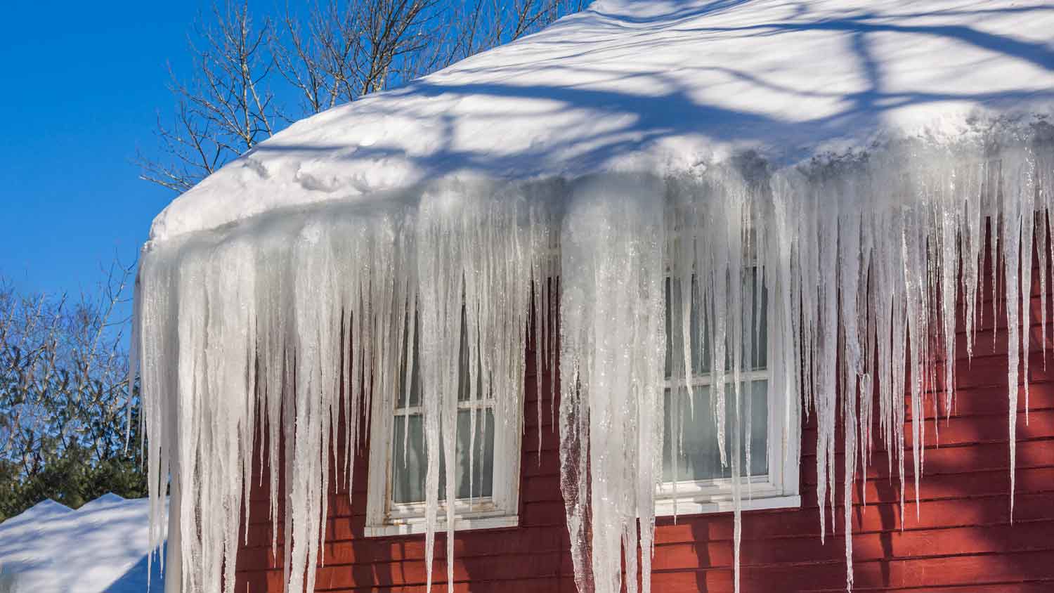 ice dams and snow on red roof