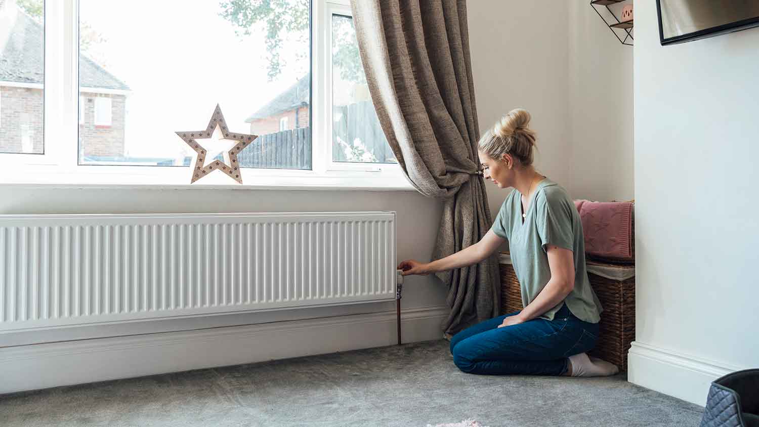Woman adjusting temperature on a radiator
