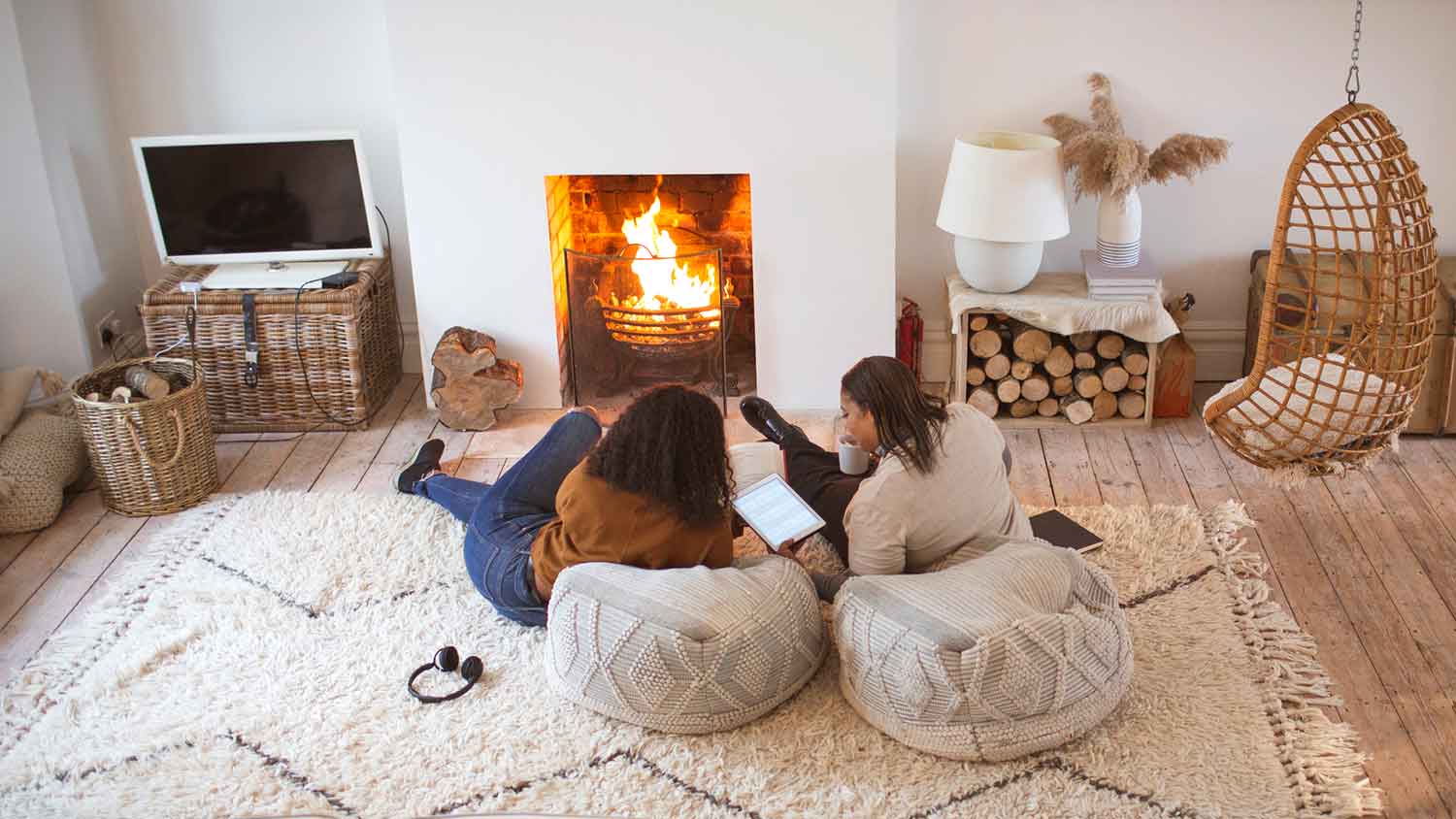 Mother and daughter at home relaxing by the fireplace