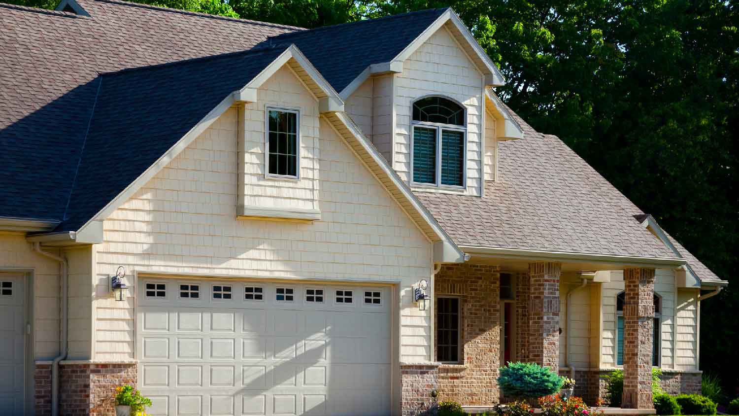 A brick house with asphalt shingles on the roof
