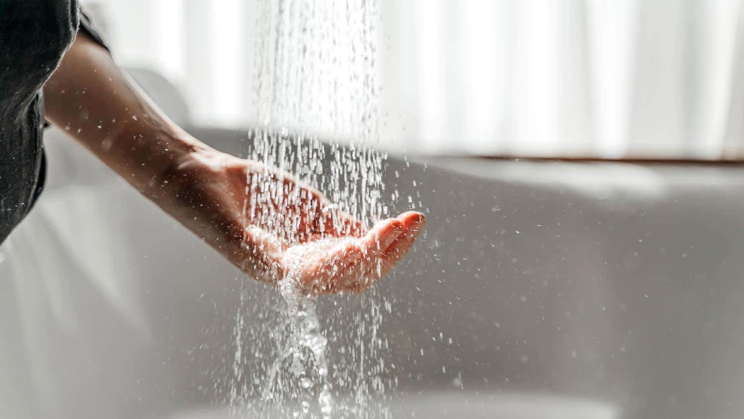 A woman feeling running water from the shower