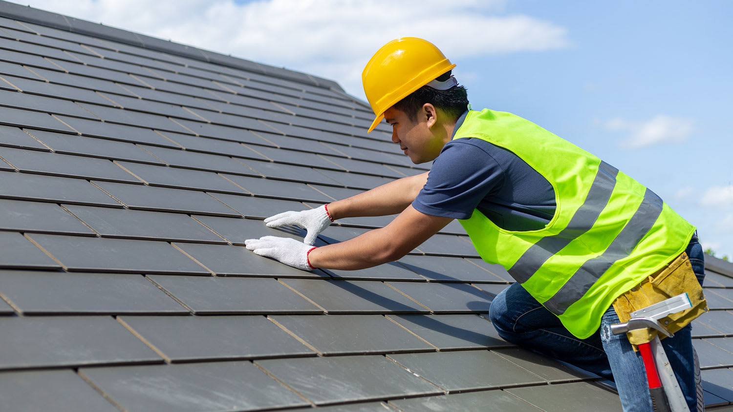 Roofer climbs on roof to inspect tile shingle