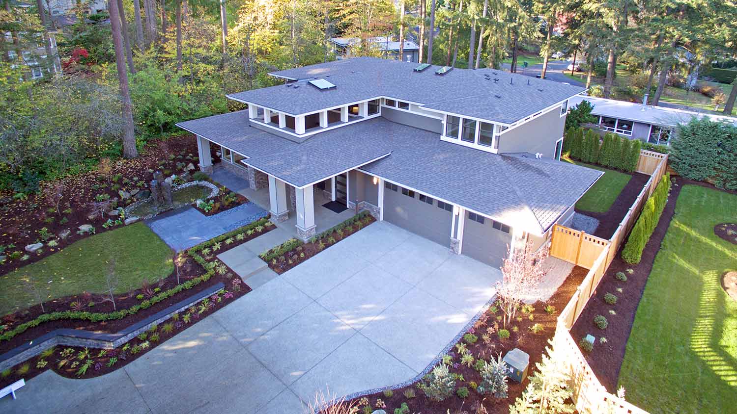 Aerial view of a two story home with a grey roof