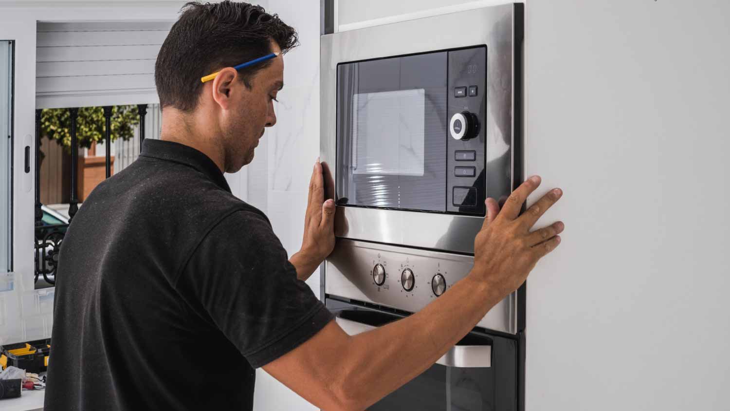 Man fitting a microwave