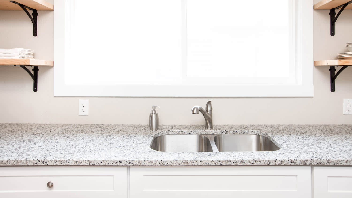 Kitchen with granite countertop and wooden floating shelves