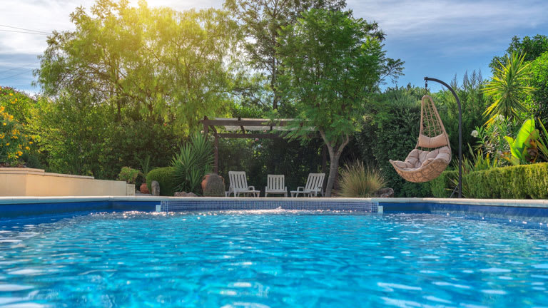 Luxurious pool in the garden of a private villa, hanging chair with pillows