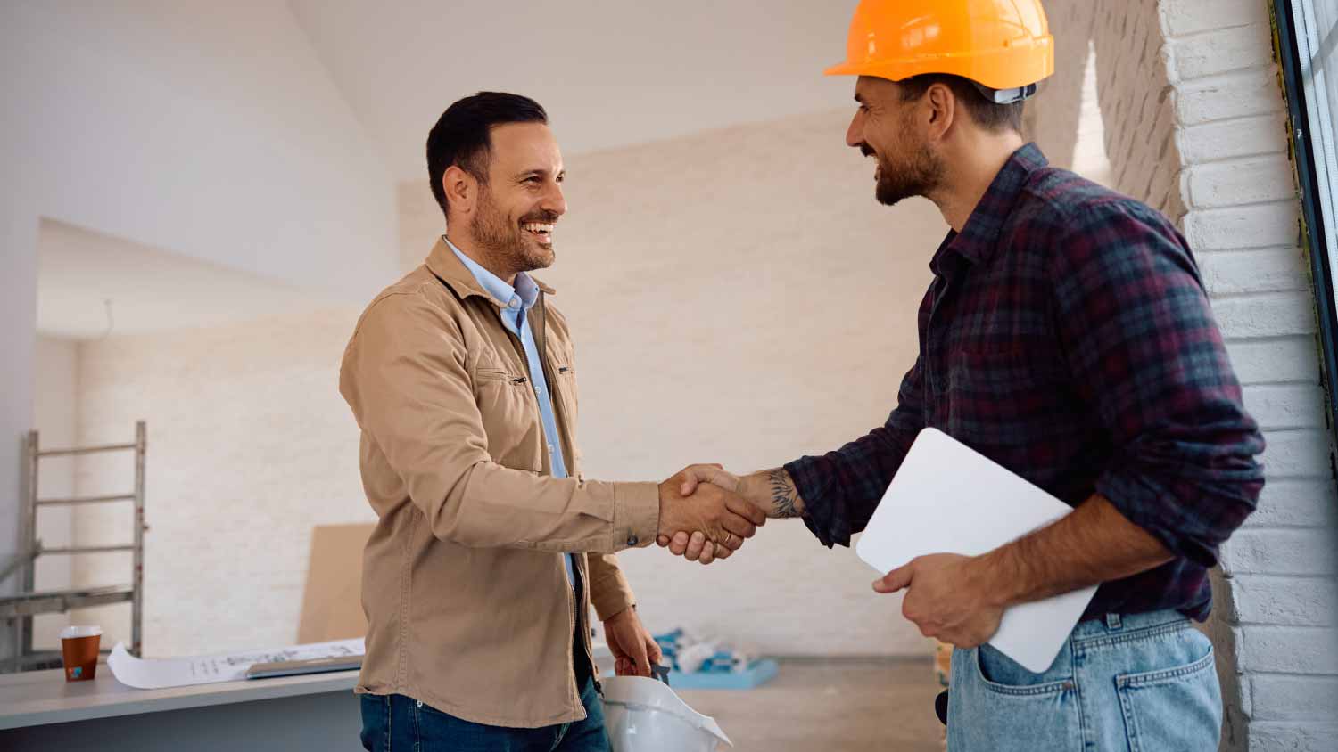 Worker handshaking at renovating house