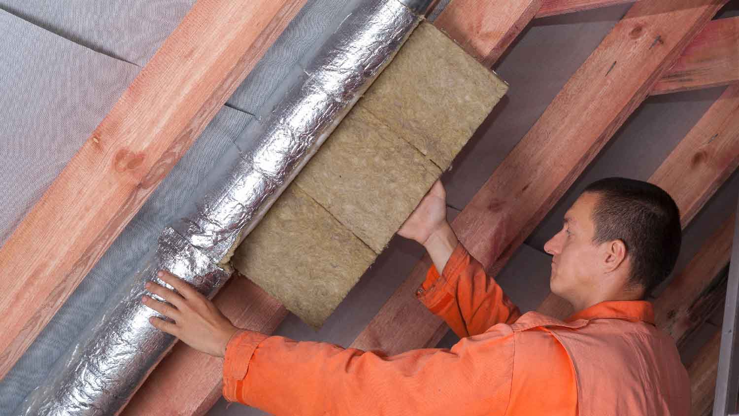 A person installing insulated ducts