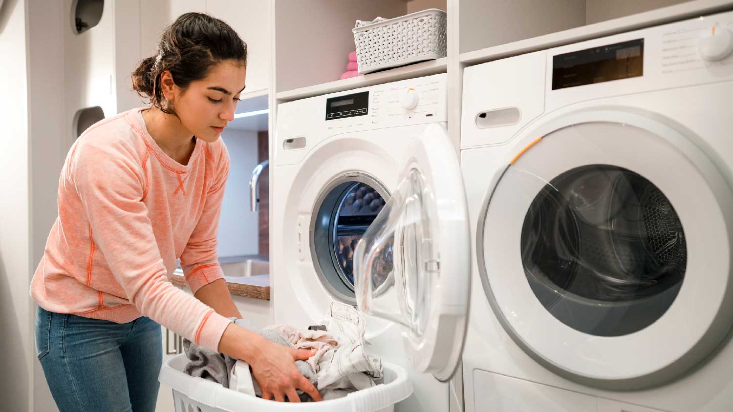 A woman loading a dryer with clothes