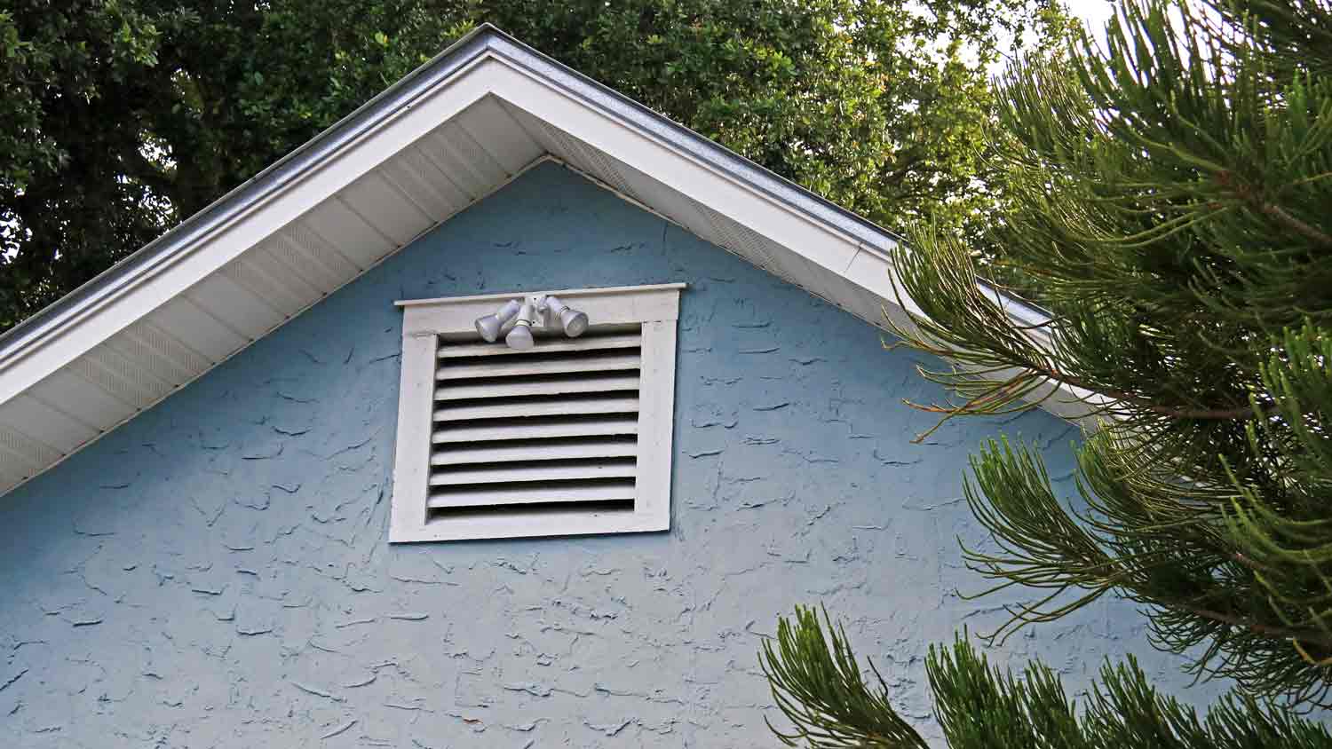blue house with attic ventilation window