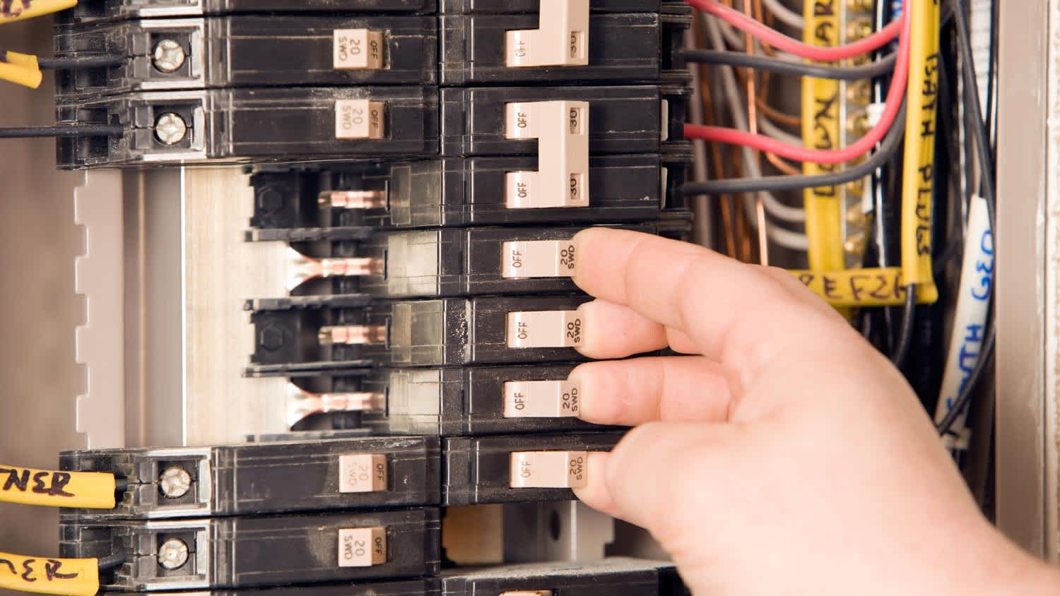 Close-up of an electrician turning on circuit breakers