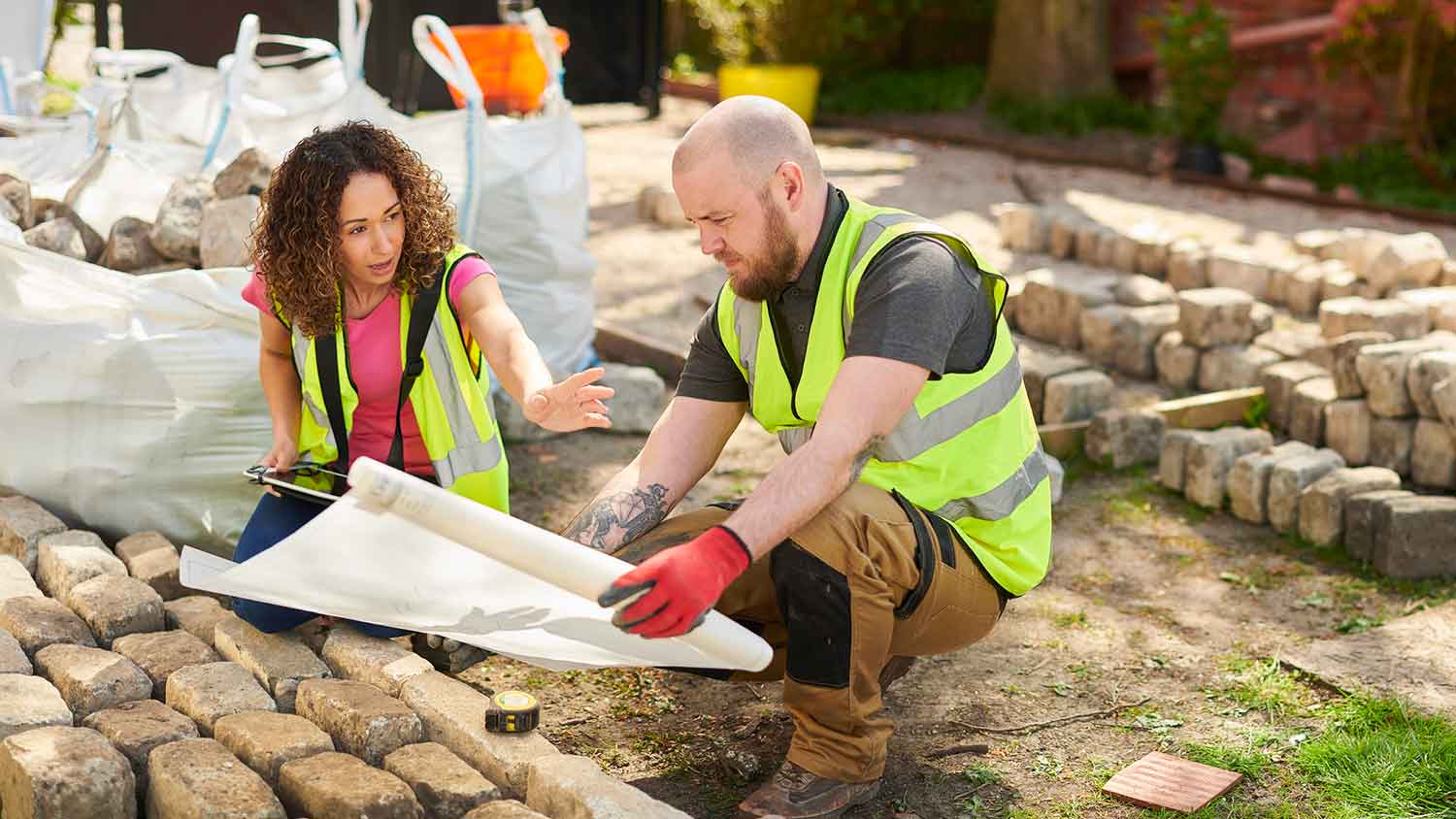 Professional landscapers reviewing plan drawing