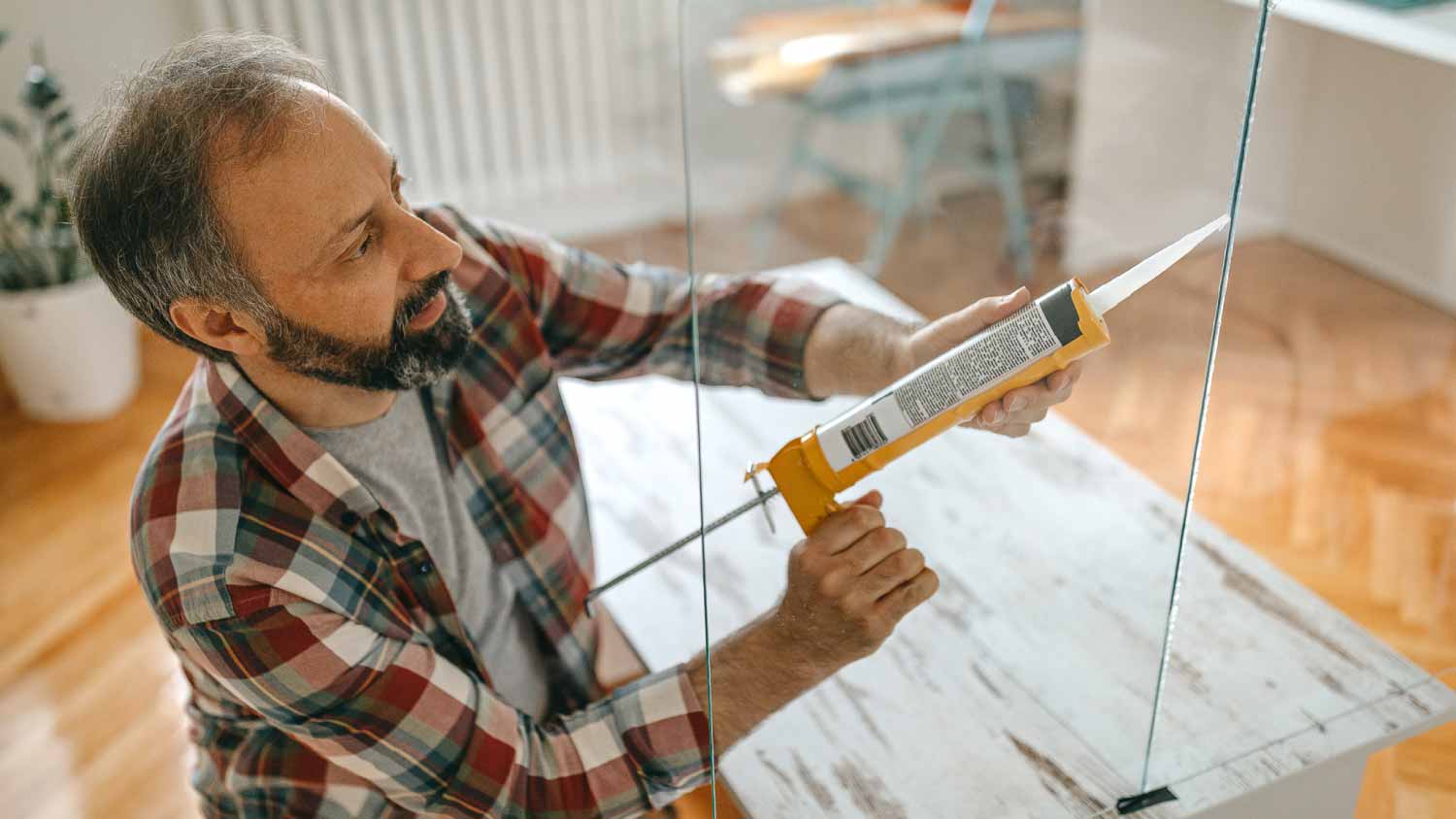 Man caulking a glass partition