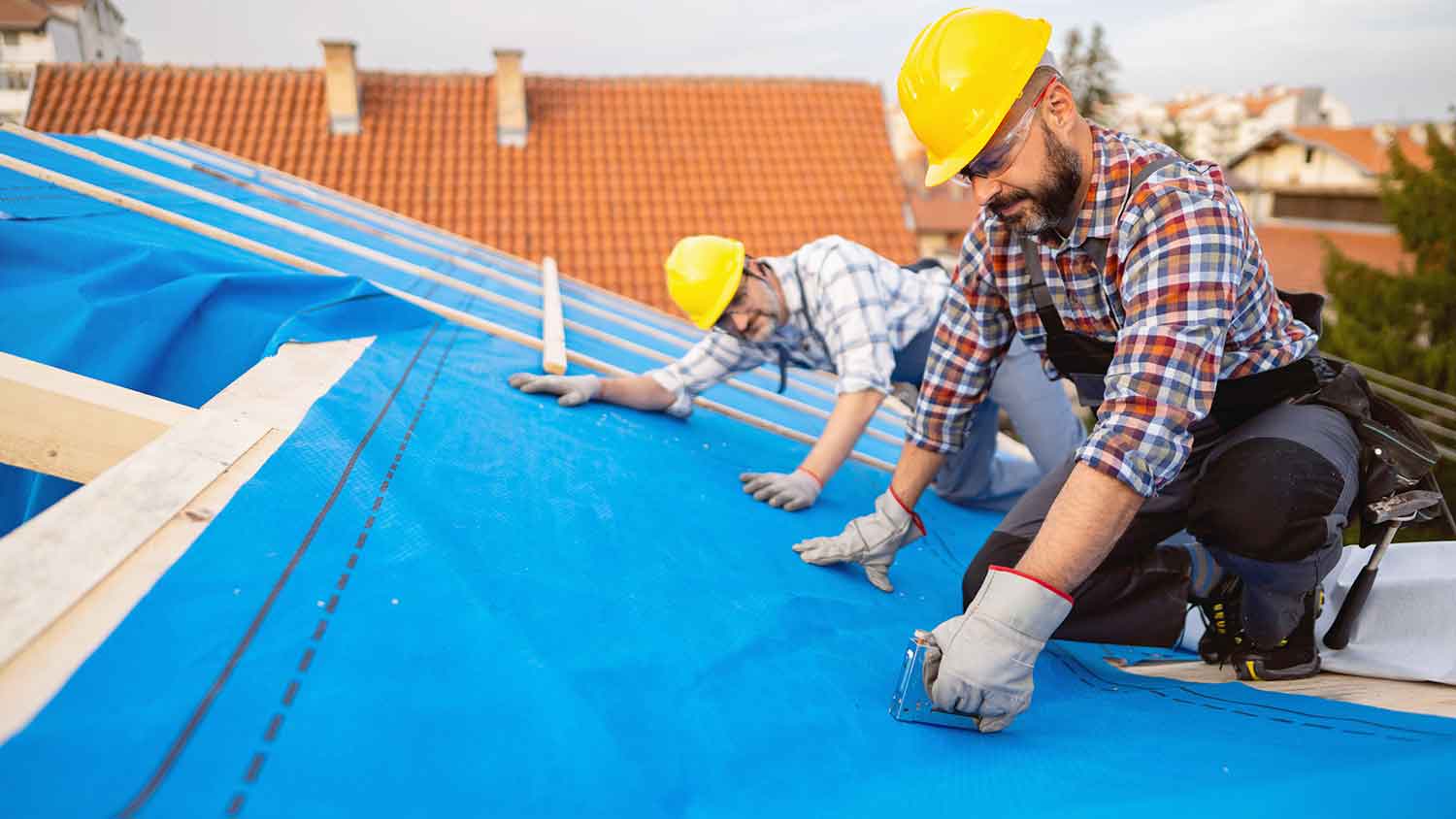 Roofing contractor installing roof underlayment replacement