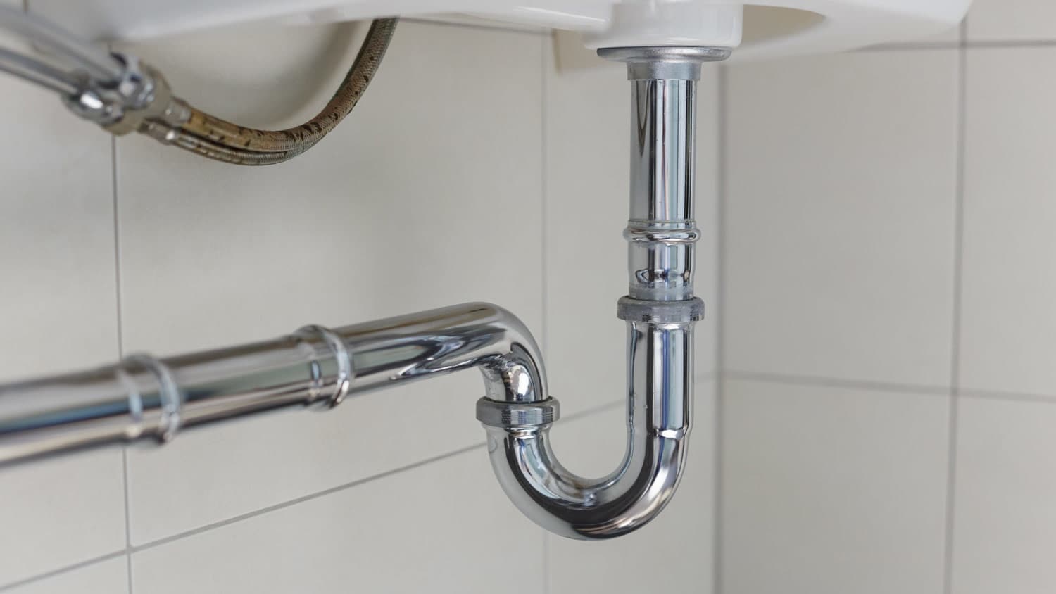 close up of drain in white bathroom