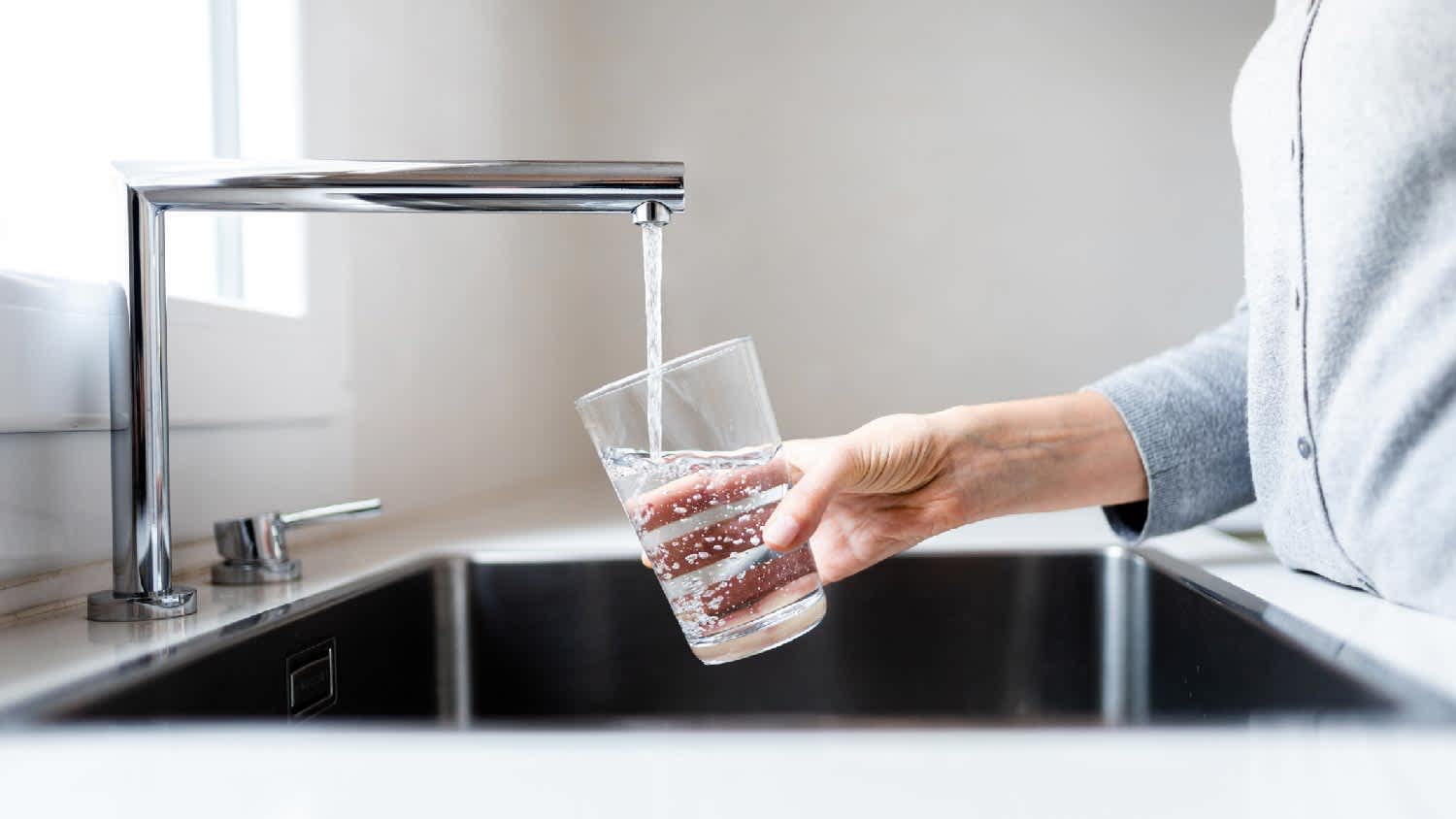 A woman filling a glass with tap water
