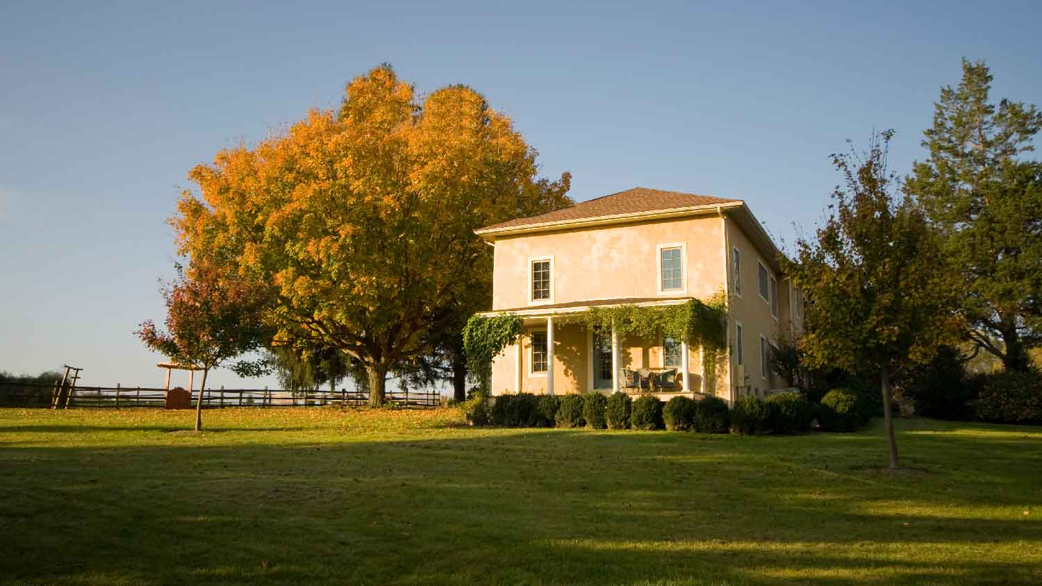 A house with a large field as its front yard