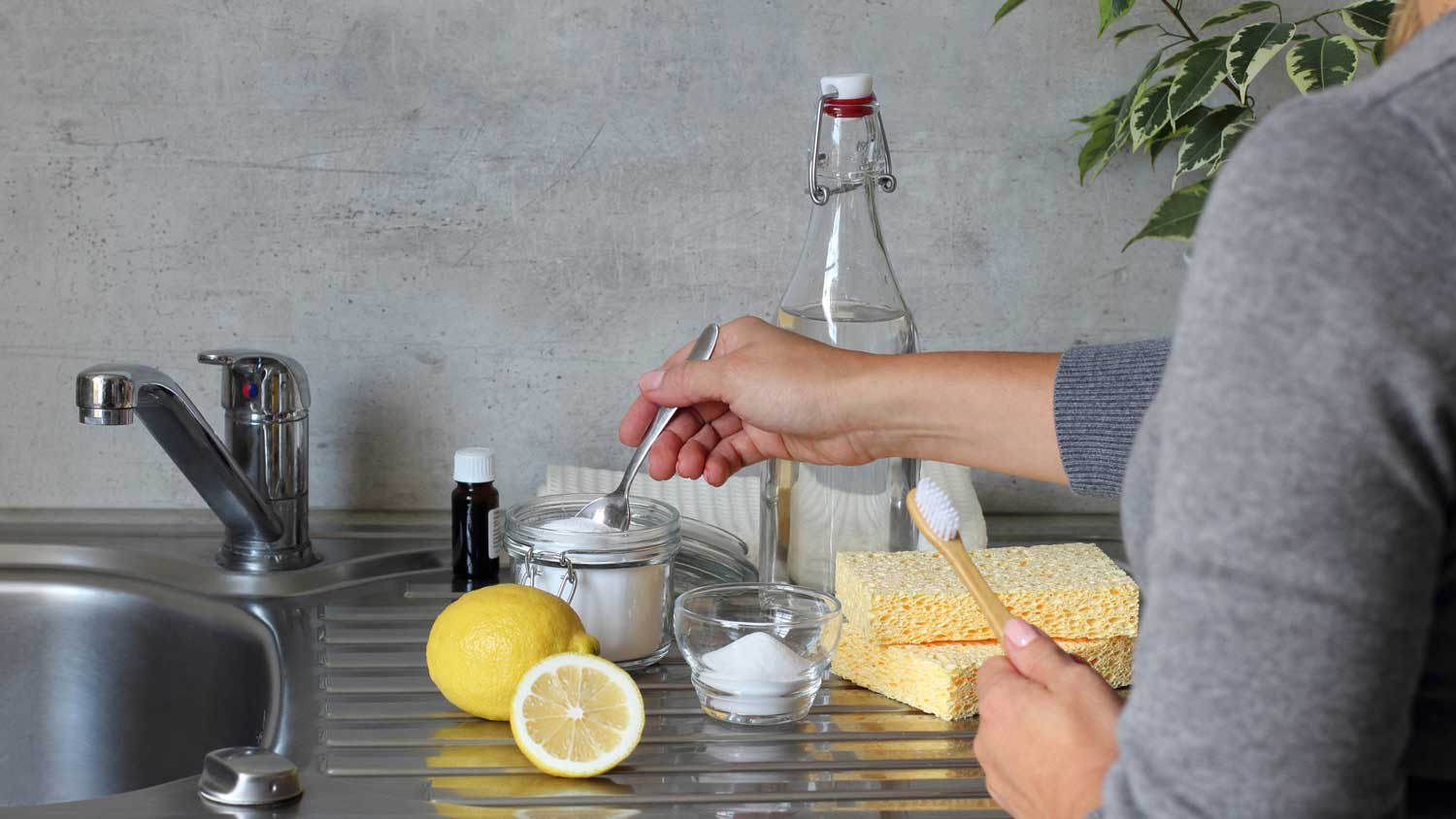 Woman preparing a sink cleaner with baking soda and lemon juice