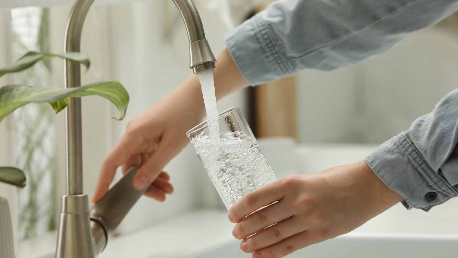 Woman filling glass with water
