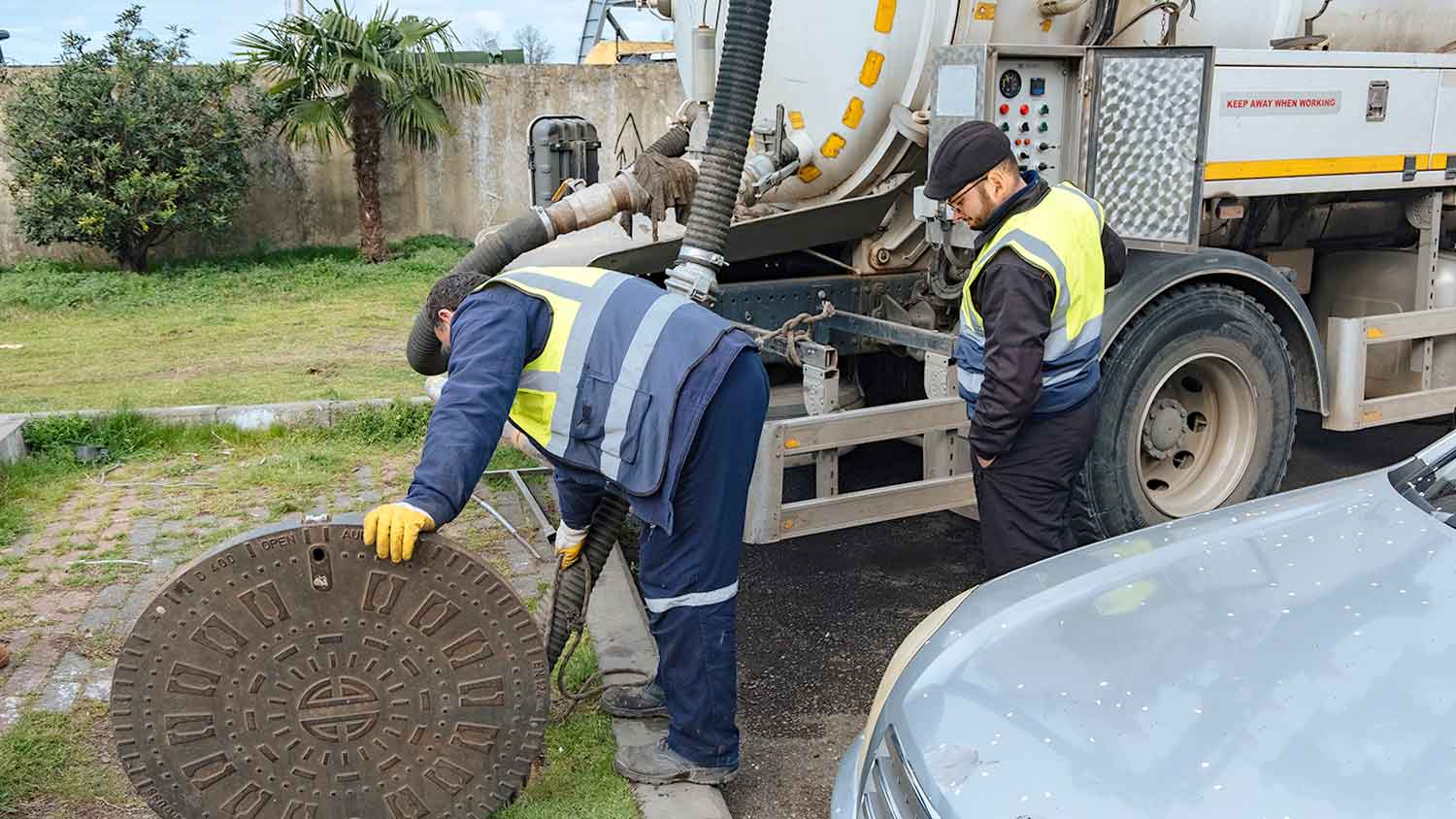 Septic professionals using vacuum truck to empty septic tank
