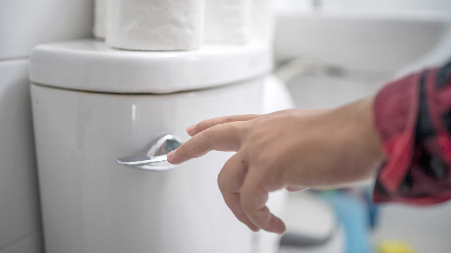 Closeup of a hand flushing the toilet
