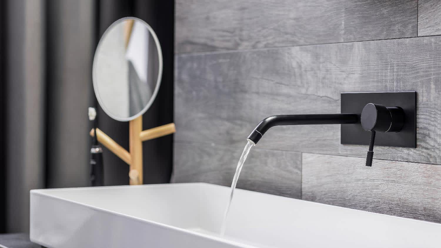 Water running from wall-mounted faucet