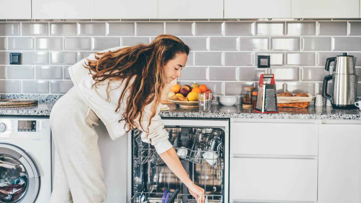 Woman putting dishes in dishwasher